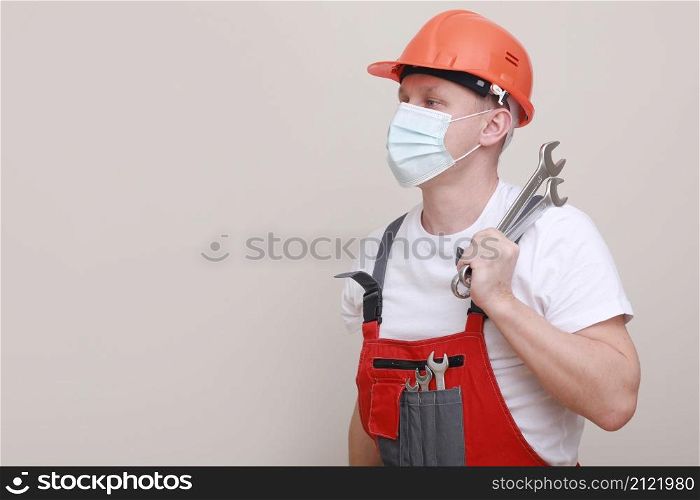 portrait engineer worker or mechanic wearing helmet and face mask for protect virus covid 19 on white background, with holding wrench. labor day.. portrait engineer worker or mechanic wearing helmet and face mask for protect virus covid 19 on white background, with holding wrench. labor day