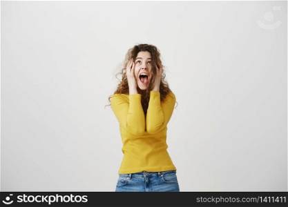 Portrait excited screaming young woman standing isolated over white background. Looking camera. Portrait excited screaming young woman standing isolated over white background. Looking camera.