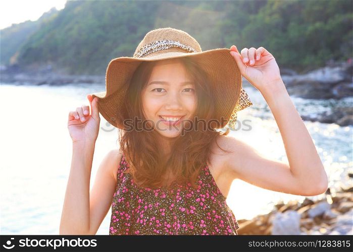 portrait face of beautiful woman wearing wide straw hat standing at sea side eyes looking to camera use for people on vacation and natural beauty of young and teen