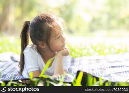 Portrait face of cute asian little girl and child happiness and fun in the park in the summer, smile and happy from asia kid and relax in the garden, lifestyle childhood concept.