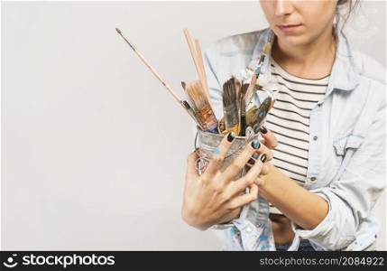portrait female artist with paintbrushes