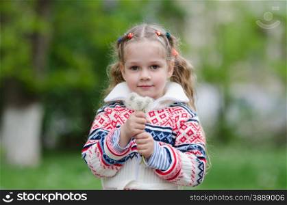 Portrait four-year girl with bouquet white dandelions in the hands of. Half-length portrait four-year girl in a jacket with a bouquet of dandelions in the hands of