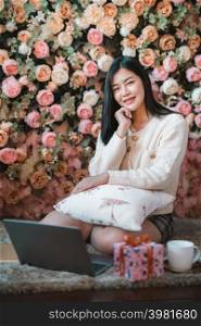 Portrait freelance business beautiful positive smile young asian woman girl wearing warm clothes online working with laptop computer with coffee cup mug at house home in the living room inside or cafe