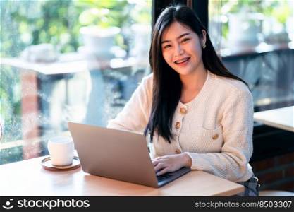 Portrait freelance business beautiful positive smile young asian woman online working with laptop computer and a coffee cup at home in the living room indoors or the cafe,Business Lifestyle