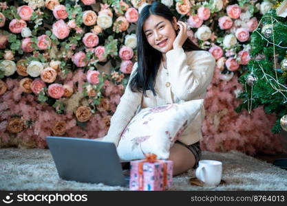 Portrait freelance business beautiful positive smile young asian woman online working with laptop computer at home in the living room indoors Decoration During Christmas x-mas and New Year holidays.