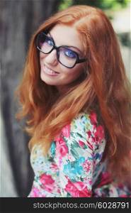 Portrait funny redhead girl with glasses. Photo toned style Instagram filters