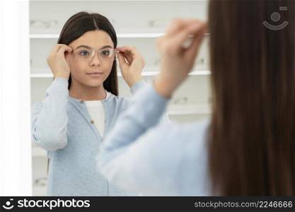 portrait girl eyeglasses store trying glasses