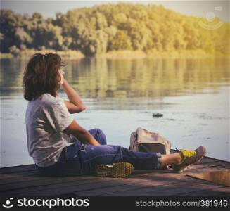 portrait girl hiker with a backpack sitting on the banks of the Dnieper River