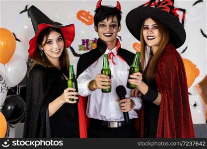 Portrait group of friends asian young adult people celebrate Halloween party carnival festive. They wear Halloween costume sing a song and cheers. Halloween celebrate and international holiday concept