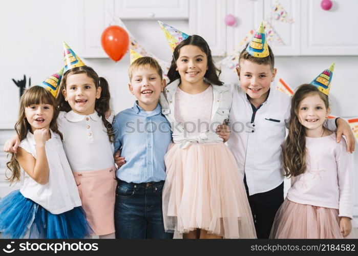 portrait happy friends wearing party hat standing together