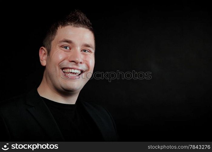 Portrait happy laughing man on black background