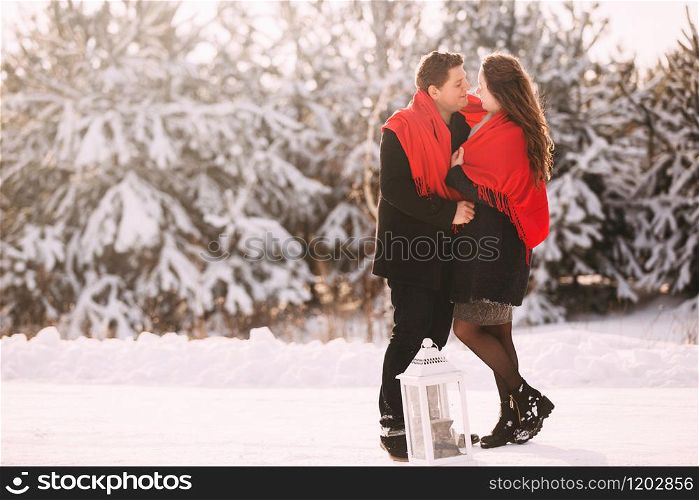 Portrait happy loving couple outdoors hugging and kissing, standing in winter forest park. Emotions of happiness. Concept of friendly family holiday. full length. Close Up. Love in Valentine&rsquo;s Day