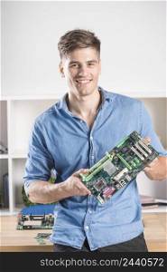 portrait happy male technician holding modern computer motherboard