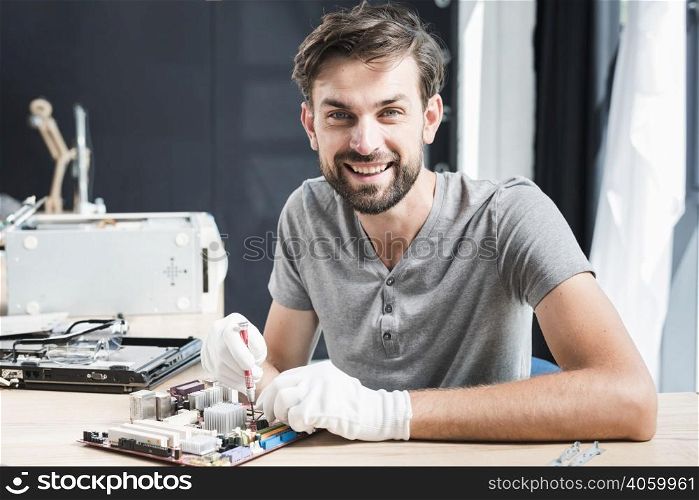 portrait happy man repairing circuit board computer