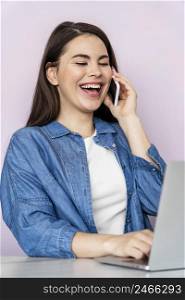 portrait happy woman talking phone using laptop