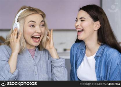 portrait happy women laughing listening music headphones