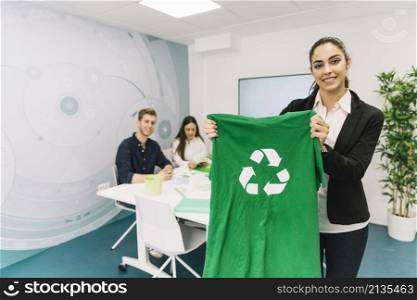 portrait happy young businesswoman showing green t shirt with recycle icon