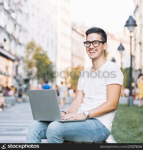 portrait happy young man with laptop