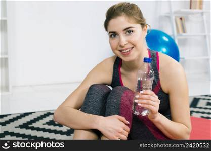portrait happy young woman holding plastic water bottle