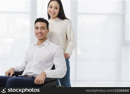 portrait happy young woman standing man sitting wheelchair
