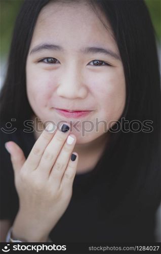 portrait headshot of beautiful asian teenager looking with eyes contact outdoor