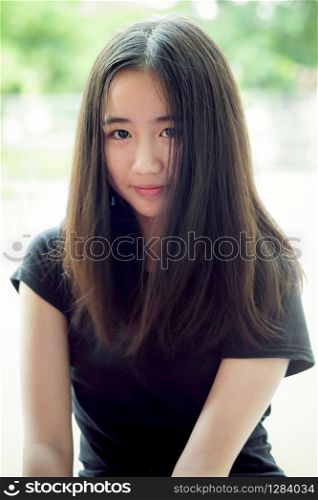 portrait headshot of beautiful asian teenager looking with eyes contact outdoor