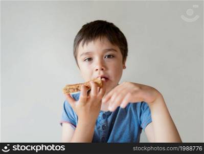 Portrait healthy Child boy eating honey on toasted for his breakfast before go to school, Happy kid child eating butter on bread in the morning, Healthy food for children concept
