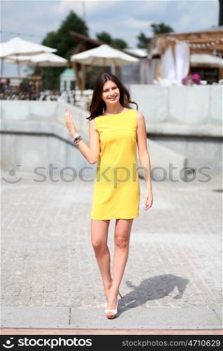 Portrait in full growth, attractive young woman in yellow dress &#xA;&#xA;