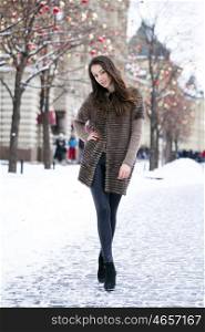 Portrait in full growth of a beautiful stylish young woman on the background Red Square, Moscow Kremlin, Russia