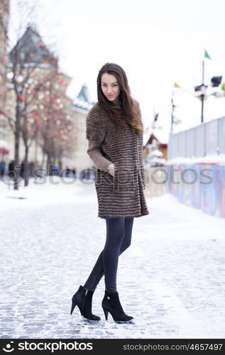 Portrait in full growth of a beautiful stylish young woman on the background Red Square, Moscow Kremlin, Russia