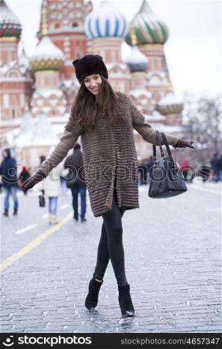 Portrait in full growth of a beautiful stylish young woman on the background of St. Basil's Cathedral, Moscow Kremlin, Russia