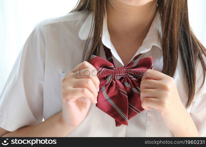 Portrait japanese school girl dressing school uniform in white tone bed room