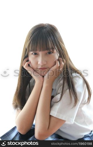 Portrait japanese school girl uniform sitting and look at camera in white tone bed room