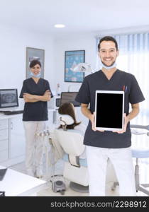 portrait male dentist showing digital tablet clinic