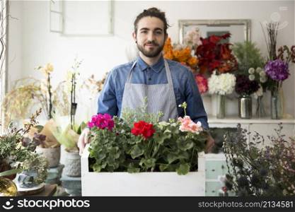 portrait male florist holding colorful hydrangea flowers crate