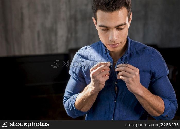 portrait man buttoning his blue shirt