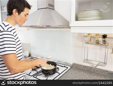 portrait man frying popcorn sauce pan kitchen