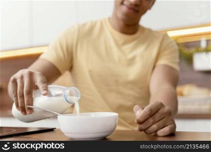 portrait man home pouring milk bowl