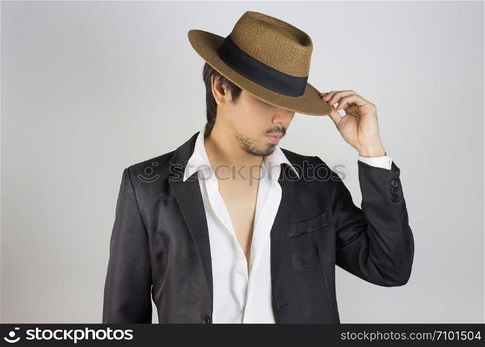 Portrait Man in Black Suit and White Shirt and Hat Fashion on Front Side View. Man in black suit with brown straw hat on grey background in smart style