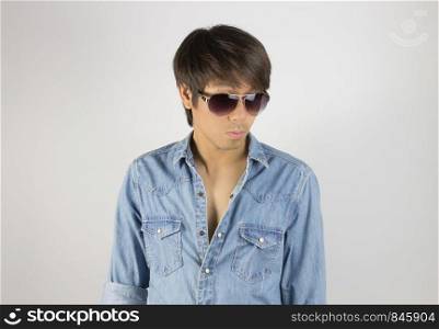 Portrait Man in Jeans Shirt Fashion Wear Eyeglasses Looking Below. Jeans shirt or denim shirt fashion for men on grey background