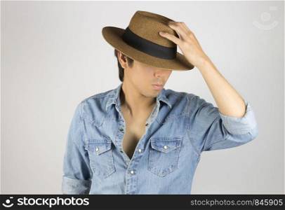 Portrait Man in Jeans Shirt or Denim Shirt Fashion Touching Hat. Jeans shirt or denim shirt fashion for men on grey background