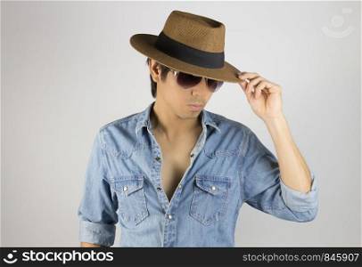 Portrait Man in Jeans Shirt or Denim Shirt Fashion Wear Eyeglasses and Hat. Jeans shirt or denim shirt fashion for men on grey background