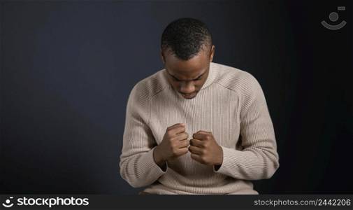 portrait man sitting with clenched fists