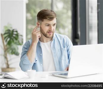 portrait man with airpods working laptop