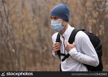 portrait man with face mask backpack woods