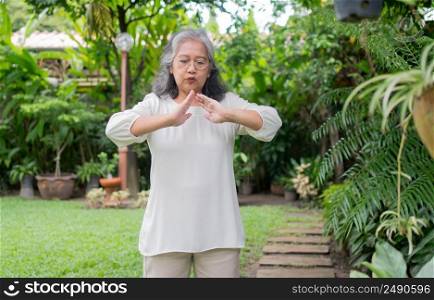 Portrait of a Asian Senior woman doing yoga and stretching exercise in the garden for a workout. Concept of lifestyle fitness and healthy. Asian women are practicing yoga in park. Healthy lifestyle