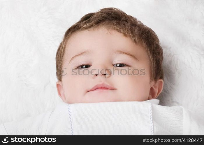 Portrait of a baby boy resting on the bed