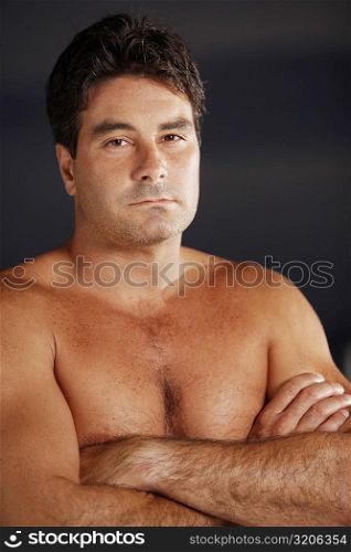 Portrait of a bare chested mid adult man with his arms crossed
