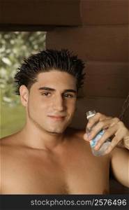 Portrait of a bare chested young man holding a water bottle