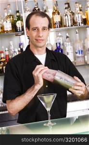 Portrait of a bartender preparing a martini